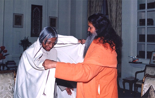 Mahamandaleshwar Paramhans Swami Maheshwarananda is putting a shawl over President\'s shoulders to greet and honour him