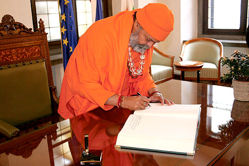 His Holiness Mahamandaleshwar Paramhans Swami Maheshwarananda is signing the Ljubljana\'s Town Hall Book of visitors